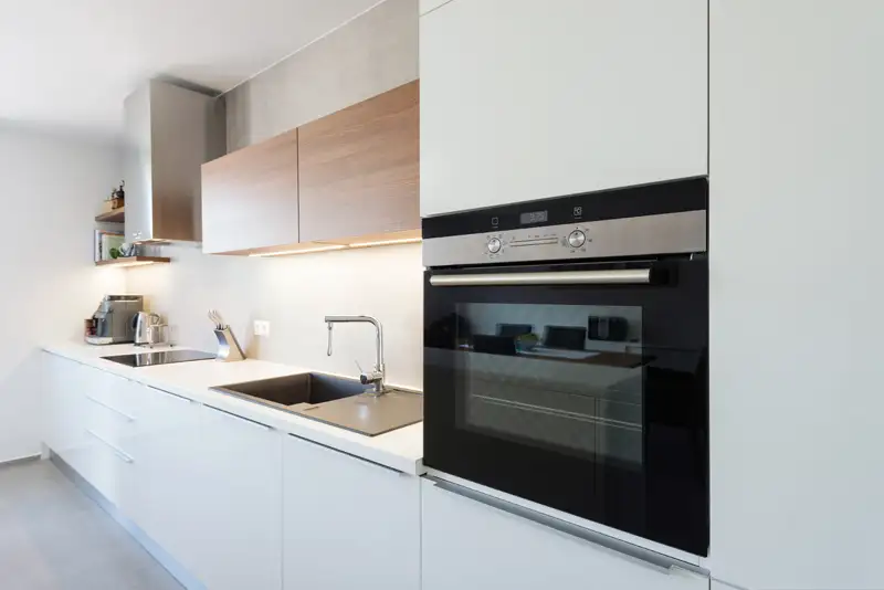 a kitchen with white cabinets and black oven